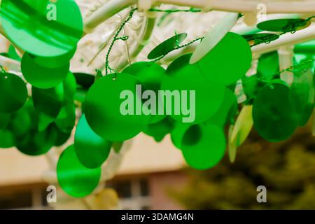 A macro view of bright green circular decorations hanging from strings, illuminated by warm afternoon light. The shallow depth of field and soft backg Stock Photo