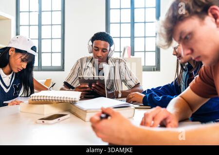 Multiethnic group of young students meeting at the library - multiethnic group of young students collaborating and learning in a university library, u Stock Photo