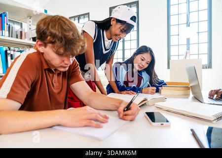 Multiethnic group of young students meeting at the library - young multiethnic students collaborating on assignments, writing notes and reading books Stock Photo
