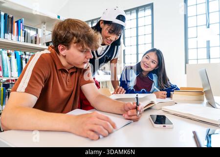Multiethnic group of young students meeting at the library - group of multiethnic young students collaborating on an educational project, learning and Stock Photo