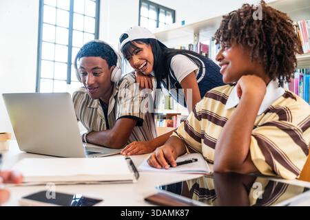 Multiethnic group of young students meeting at the library - group of diverse college students collaborating on research project in modern university Stock Photo