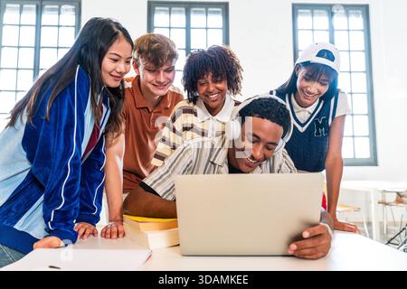 Multiethnic group of young students meeting at the library - diverse group of young students collaborating and learning at a study table, sharing a la Stock Photo