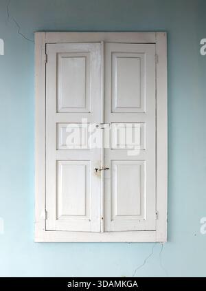 Closed white wooden shutters on the window Stock Photo