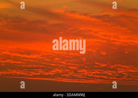 View of fiery sunset paints the sky with vibrant oranges and reds, creating an intense and captivating scene, Karachi, Sindh, Pakistan. Stock Photo