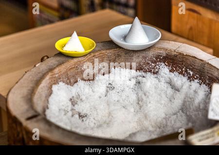 Small salt cones, called morishio, sit in bowls on a wooden salt vessel in Ise, Mie Prefecture, Japan. Throughout Japan they are regarded as a symbol of purification, since salt separates the pure from the impure. Stock Photo
