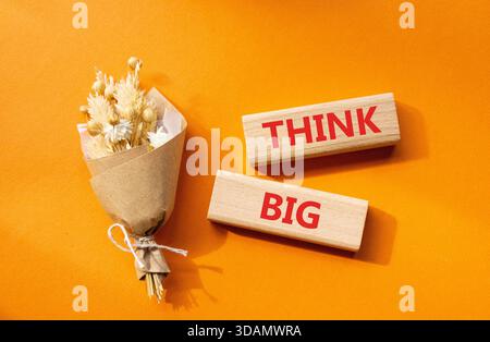 Think big symbol. Wooden blocks with words Think big. Beautiful orange background. Business and Think big concept. Copy space. Stock Photo