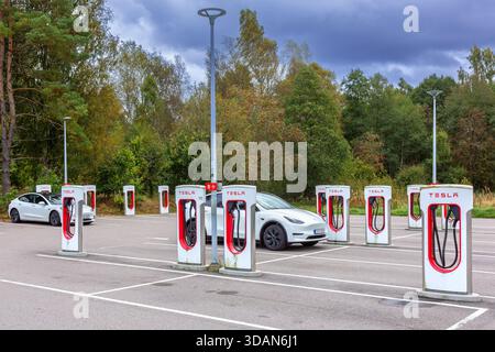 Parking area with public charging station / loading points from Tesla, network of rapid chargers for electric vehicles / cars in Sweden Stock Photo