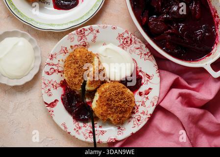 Traditional Austrian cottage cheese dumplings in breadcrumbs with plum compote and sour cream.top veiw.style hugge.selective focus Stock Photo