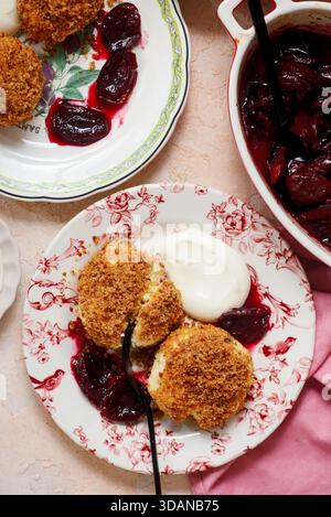 Traditional Austrian cottage cheese dumplings in breadcrumbs with plum compote and sour cream.top veiw.style hugge.selective focus Stock Photo