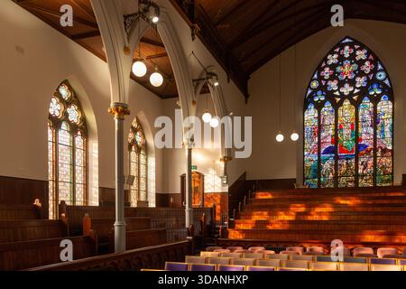 Old wooden church pews and stained glass windows in St Brycedale Church, Kirkcaldy, Fife, Scotland Stock Photo
