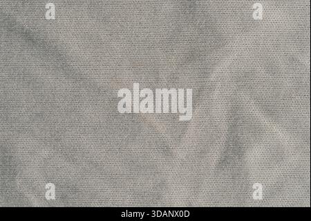 Fabric displays folds and creases in a neutral color with a smooth surface. Light plays on the texture creating depth. Stock Photo