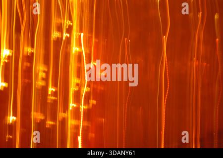 Abstract vertical golden light streaks background. Falling rain of light texture suitable for New Year or celebration overlay. Stock Photo