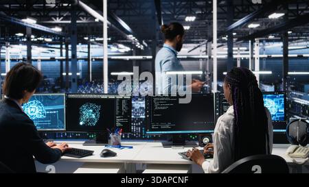 Data center manager checking work done by admins using deep learning to analyze datasets. Server hub supervisor overseeing IT specialists using AI neural networks to recognize data patterns, camera A Stock Photo
