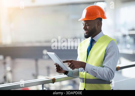 Construction Worker Using Tablet in Industrial Setting During Daytime Stock Photo