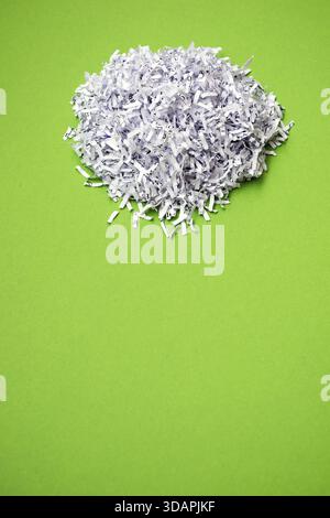 Shredded paper heap on the bright green background Stock Photo