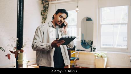 Tablet, phone call and barber with business in salon for communication for appointment schedule. Digital technology, cellphone and male hairdresser on Stock Photo