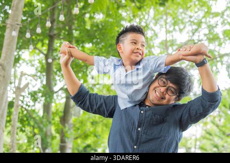 Portrait of dad playing with his son on nature background. Father and little son are playing and having fun outdoors. Fathers day, holiday, happy fami Stock Photo