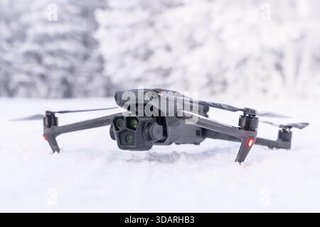 A black drone on the background of a winter forest. Winter aerial photography and aerial photography from drones while traveling. Features of Stock Photo