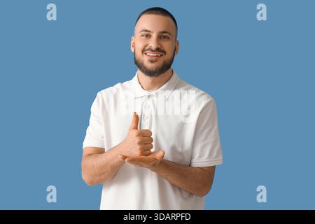 Handsome man using sign language on blue background Stock Photo