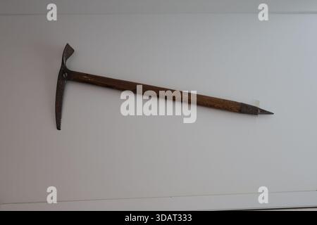 Vintage mountaineering ice axe on white wall Stock Photo
