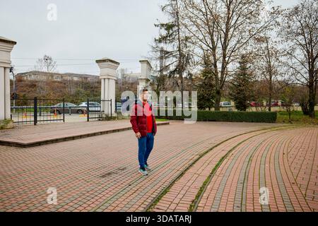 A middle-aged man walks through the park in the morning and relaxes on a late autumn day. Stock Photo