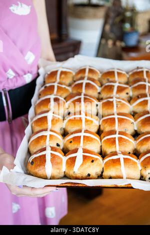 Freshly Baked Hot Cross Buns on Tray Held by Woman in Pink Dress Stock Photo