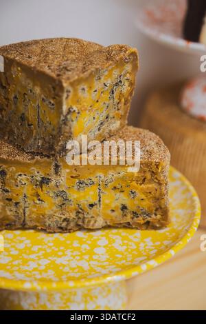 Stacks of yellow, blue cheese on yellow plate Stock Photo