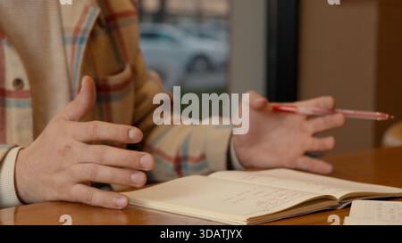 Close-up of two people discussing notes and documents on a cafe table Stock Photo
