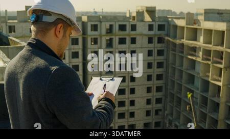 Construction worker or engineer on site checking the building plans on tablet Stock Photo