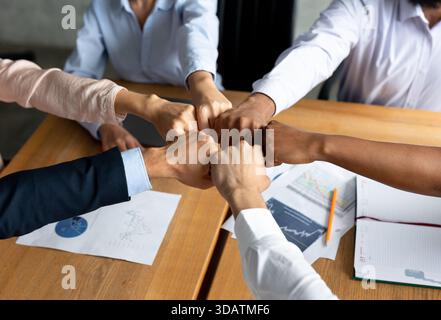 Business Team Celebrates Unity Through Fist Bumps in Diverse Office Meeting Stock Photo