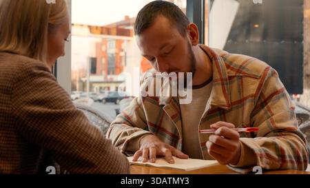 Two young men engaged in a serious discussion over a table in a cafe Stock Photo
