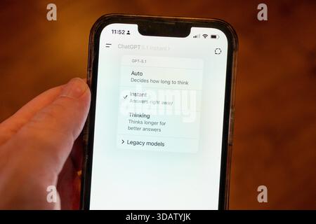 Person's hand holding an iPhone using the OpenAI GPT-5.1 model within the ChatGPT app, showing the Instant and Thinking versions of the model, Lafayette, California, November 13, 2025. (Photo by Smith Collection/Gado/Sipa USA) Stock Photo