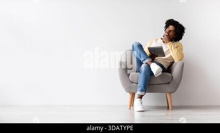 Thoughtful African American Man Considering Options While Using Digital Tablet in Modern Setting Stock Photo