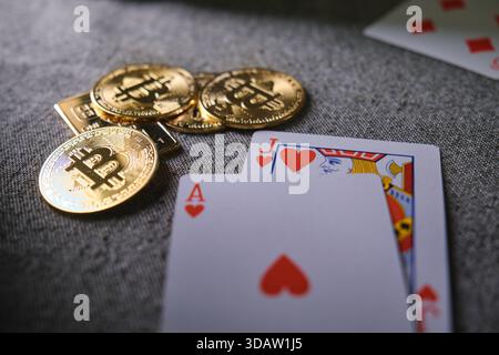 Bitcoin cryptocurrency coins and casino playing cards on a gray fabric surface Stock Photo