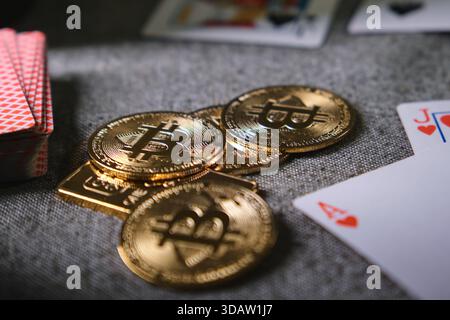 Golden bitcoin coins and poker cards representing online gambling and digital finance Stock Photo