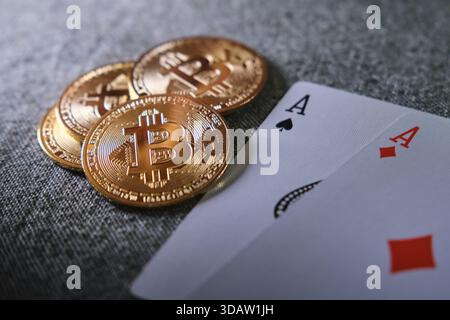 Bitcoin coins stacked on a table with playing cards, symbolizing crypto gambling risk Stock Photo