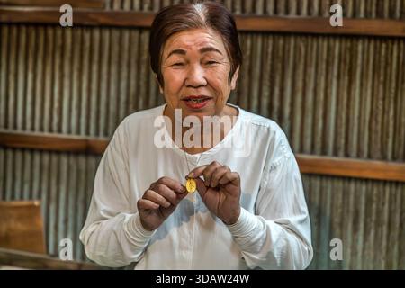 Ama diver Kimiyo Hayashi shows the protective amulet she always wears while diving. Shima, Mie Prefecture, Japan. Stock Photo
