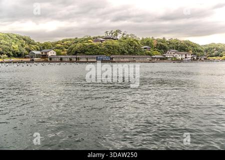From the waters of Ago Bay, you can see the extensive facilities of the Mikimoto pearl farm. Mikonoto Pearl Farm with floating buoys in Shima, Mie, Japan Stock Photo
