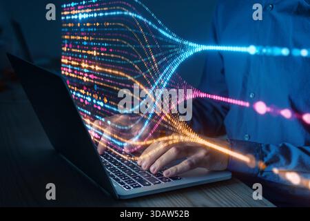 Programmer typing on laptop with colorful data flow visualization, concept of artificial intelligence, big data analysis, machine learning, and digita Stock Photo