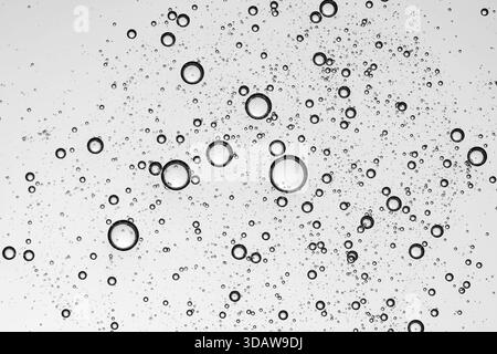 Close-up of bubbles in a clear cosmetic gel texture, showcasing intricate and artistic patterns against a white background, highlighting purity and fr Stock Photo