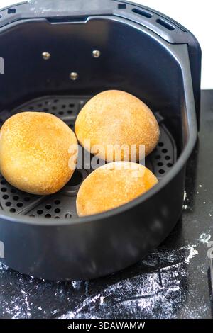 Freshly baked rolls in an air fryer, showcasing an innovative baking method at home. The golden brown crust highlights the perfect cook achieved using Stock Photo
