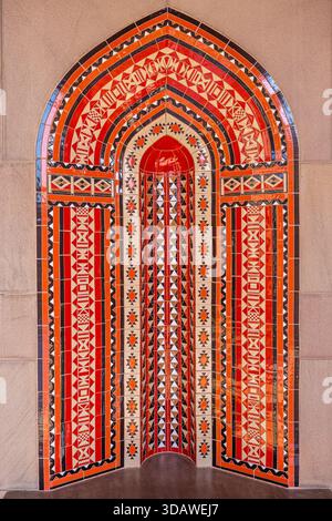 View of intricate tilework displaying vibrant patterns and colors in an arched niche, creating a captivating visual texture, Muscat, Muscat Governorat Stock Photo