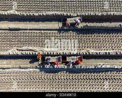 Narayanganj, Bangladesh - 09 November 2024: Aerial view of workers toiling amidst the repetitive patterns of brick fields, the landscape a tapestry of Stock Photo