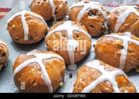 Homemade hot cross buns freshly glazed and on a cookie sheet. Stock Photo