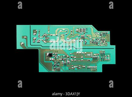 Circuit board with resistors microchips and electronic components isolated on black  background. Computer hardware technology. Stock Photo