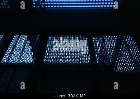 A blue stainless steel perforated sheet metal background. Stock Photo