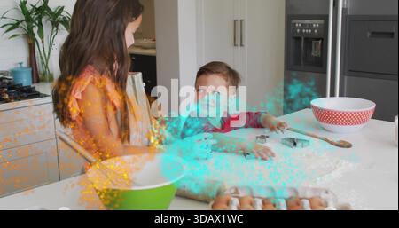 Baking siblings wearing orange dress and red shirt mixing dough at home kitchen with green bowl Stock Photo