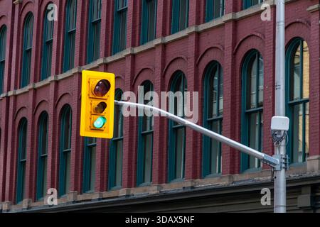 Green traffic light glowing on city street along building in Ottawa, Canada Stock Photo