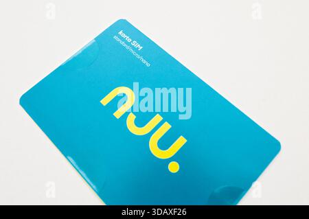 nju mobile SIM card package in blue with yellow logo and “karta SIM” text, photographed close-up on light background. Stock Photo