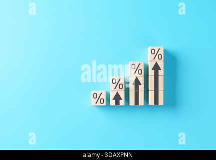 Rising interest rate or growth percentage concept shown with wooden blocks and upward arrows on blue background, symbolizing financial increase, Stock Photo